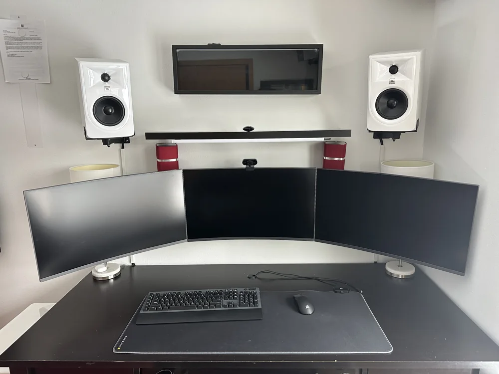 Desktop computer setup with three monitors and a pair of speakers
